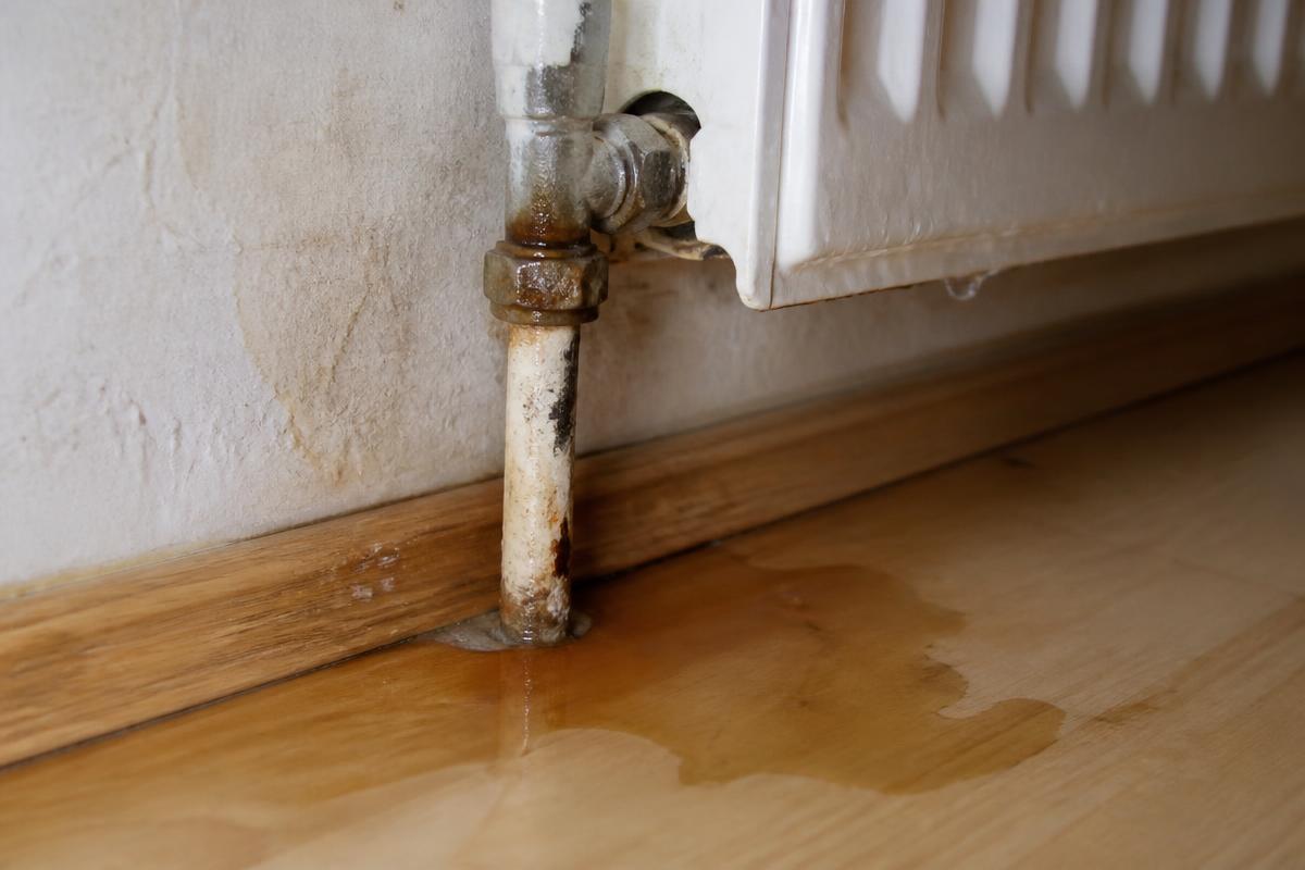 Undichter Heizkörperanschluss mit Rostspuren und Tropfwasser